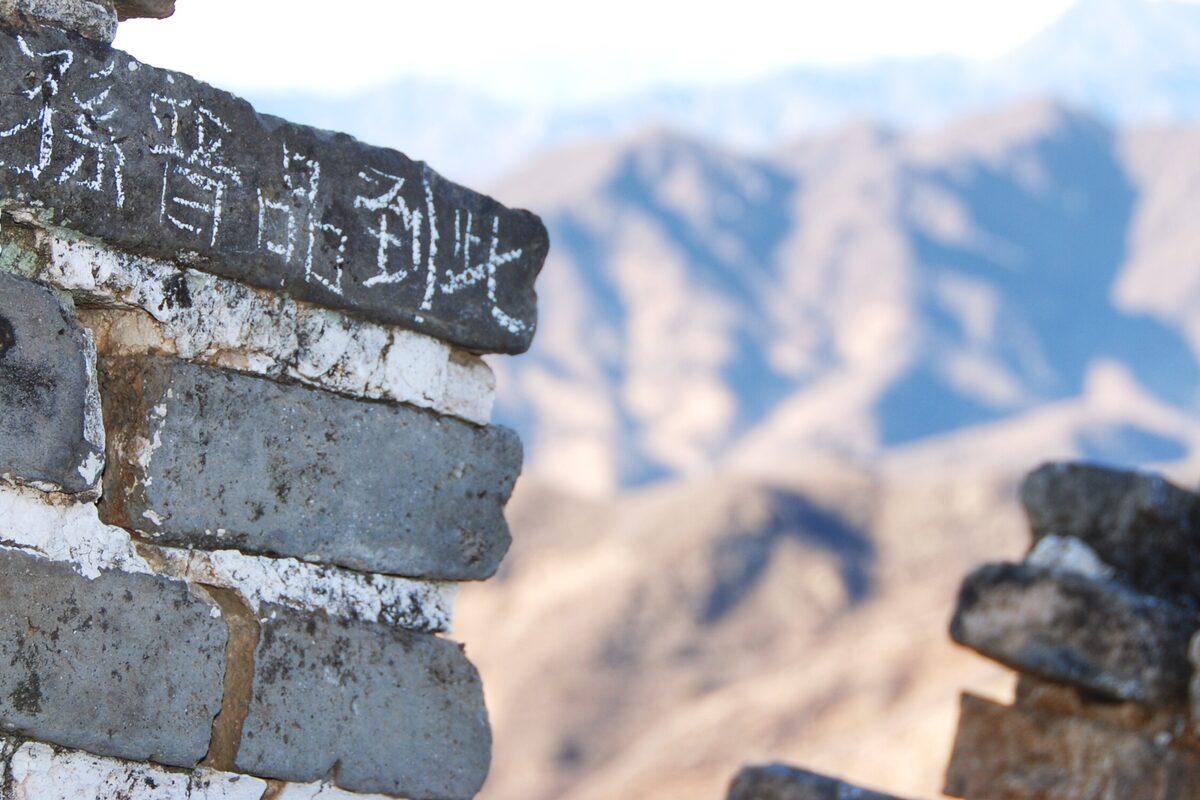 Muro de piedra de la Gran Muralla China, con las montañas al fondo